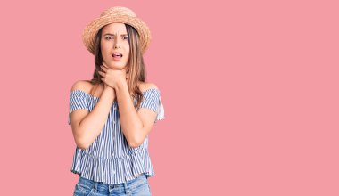 Şapka ve tişört giyen genç ve güzel bir kız boğularak can çekiştiği için bağırıyor ve boğuluyor. Sağlık problemi. Boğulma ve intihar konsepti. 