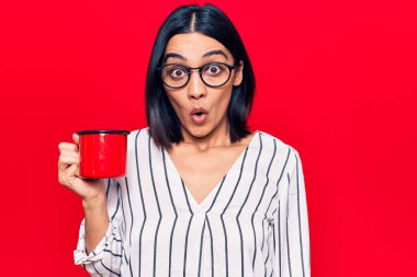 Genç, güzel, Latin bir kadın elinde kahve bardakları tutuyordu. Korkmuş ve ağzı açık bir şekilde hayrete düşmüştü. 