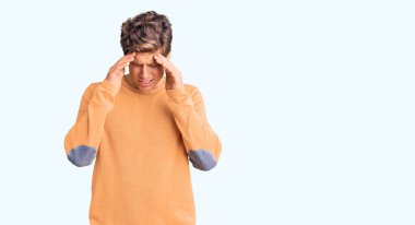 Stres yüzünden başı ağrıyan, sıradan kıyafetler giyen genç ve yakışıklı bir adam. migren ağrısı. 