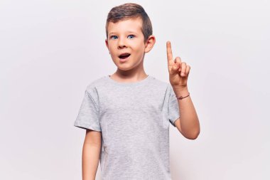 Sıradan kıyafetler giyen sevimli sarışın çocuk başarılı bir fikirle işaret ediyor. Heyecanlı ve mutlu. Bir numara.. 