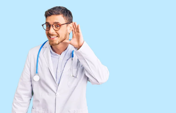 Przystojny Młodzieniec Mundurze Doktora Uśmiechający Się Ręki Ucho Słuchający Plotek — Zdjęcie stockowe