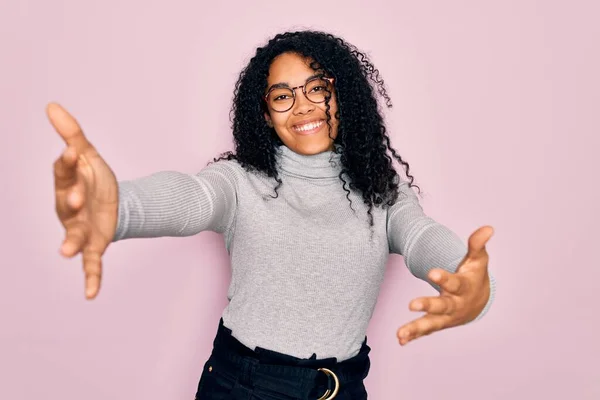 Młoda Afroamerykanka Swetrze Golfem Okularach Różowym Tle Patrząca Kamerę Uśmiechnięta — Zdjęcie stockowe
