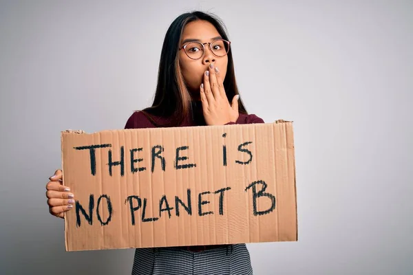 若いアジアの活動家の女の子は 地球のメッセージでバナーを保持する環境を求めて手で口をカバーミス 恐怖の表現 沈黙の中で怖がって 秘密の概念の恥でショックを受けた — ストック写真
