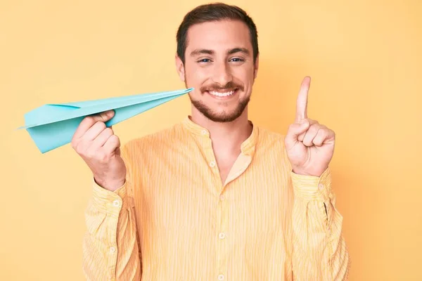 Joven Hombre Guapo Sosteniendo Avión Papel Sonriendo Con Una Idea —  Fotos de Stock