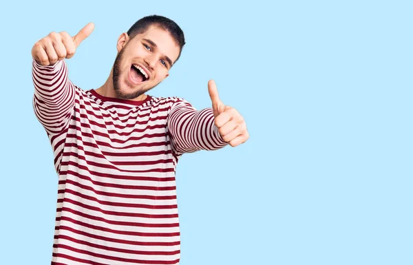 Młody Przystojniak Ubrany Sweter Paski Akceptujący Pozytywne Gesty Ręką Uśmiechem — Zdjęcie stockowe