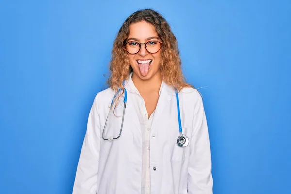 Mladá Krásná Blondýnka Doktorka Modrýma Očima Kabátě Stetoskopem Vystrkujícím Jazyk — Stock fotografie