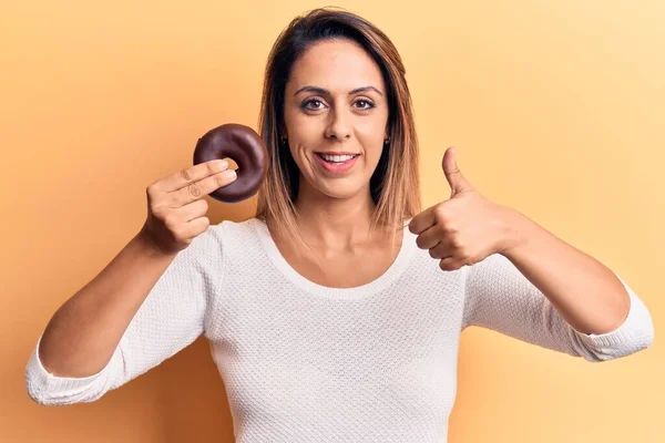 Jovem Bela Mulher Segurando Donut Sorrindo Feliz Positivo Polegar Para — Fotografia de Stock