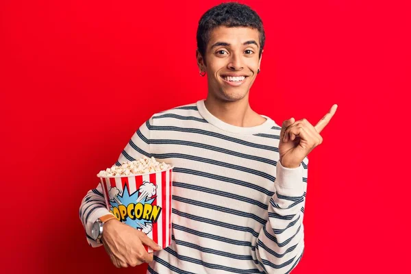 Jovem Afro Americano Segurando Pipocas Sorrindo Feliz Apontando Com Mão — Fotografia de Stock