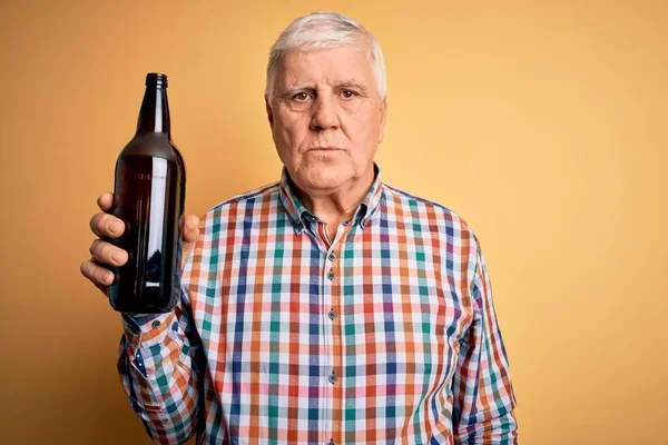Starszy Przystojny Hoary Człowiek Pije Butelkę Piwa Stojąc Odizolowanym Żółtym — Zdjęcie stockowe