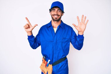 Kıvırcık saçlı ve ayı gibi giyinen yakışıklı genç adam 7 numarayı gösterip işaret ederken kendine güveni tam ve mutlu.. 