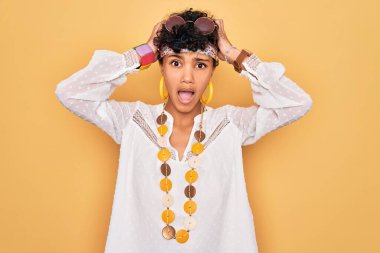 Güneş gözlüğü ve aksesuar takan Afro-Amerikan genç, güzel Afro-Amerikan kadın. Elleri başında çılgın ve korkmuş, şok geçirmekten korkan ve ağzı açık bir şekilde şaşıran.