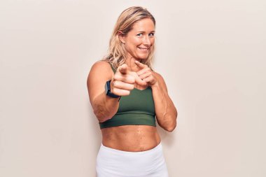 Orta yaşlı, beyaz, spor giysili, neşeli ve komik yüzlü bir kadın. iyi enerji ve titreşimler. 