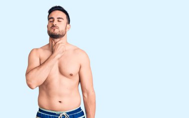 Genç yakışıklı adam mayo giyiyor, boynuna dokunuyor, boğazı ağrıyor grip, mantar ve enfeksiyon kapmış. 