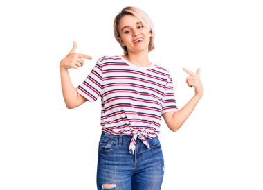 Genç, güzel, sarışın, gündelik kıyafetler giyen, kendine güvenen, gülümseyen, kendini gururlu ve mutlu gösteren bir kadın.. 