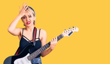 Elektro gitar çalan genç, güzel, sarışın bir kadın. Gergin ve hayal kırıklığına uğramış, şaşırmış ve sinirli bir yüzü var. 