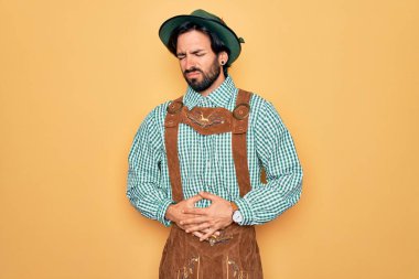 Almanya festivali için geleneksel Alman Ekim Festivali kıyafeti giyen genç yakışıklı bir adam midesi üstünde. Çünkü hazımsızlık ve acı veren bir hastalık var. Ache kavramı.