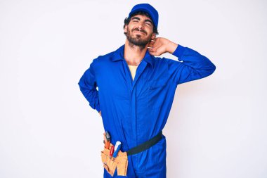 Kıvırcık saçlı yakışıklı genç adam ve ayı postu giyen, boyun ağrısı çeken, boynuna elle dokunan, kas ağrısı olan adam. 