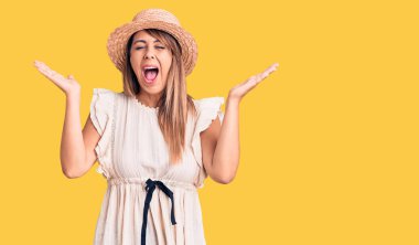 Yaz şapkası ve tişörtü giyen genç ve güzel bir kadın başarının çılgınlığını kutluyor. Kollarını kaldırmış, gözlerini kapatmış heyecanlı çığlıklar atıyor. Kazanan konsept 