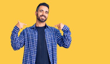 Günlük kıyafetler giyen, kendine güveni olan, kendini gururlu ve mutlu gösteren genç İspanyol bir adam.. 