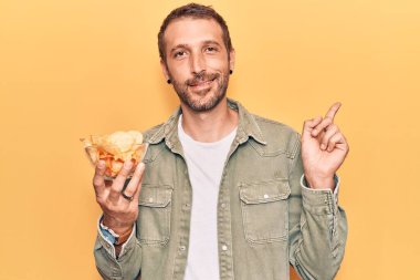 Patates cipsi tutan yakışıklı genç adam gülümsüyor. 