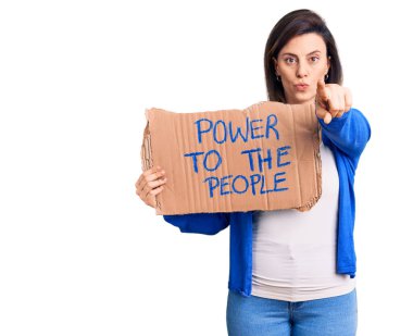 Genç ve güzel bir kadın, insanların sancağını elinde tutuyor. Parmakla kamerayı işaret ediyor. Kendine güvenen bir jest, ciddi görünüyor. 