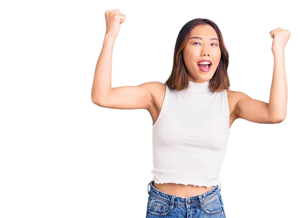 年轻美丽的中国姑娘穿着休闲装 自豪地尖叫着 高举双臂庆祝胜利和成功 — 图库照片