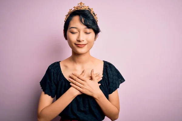 Молодая Красивая Китаянка Золотой Короне Короля Изолированном Розовом Фоне Улыбается — стоковое фото
