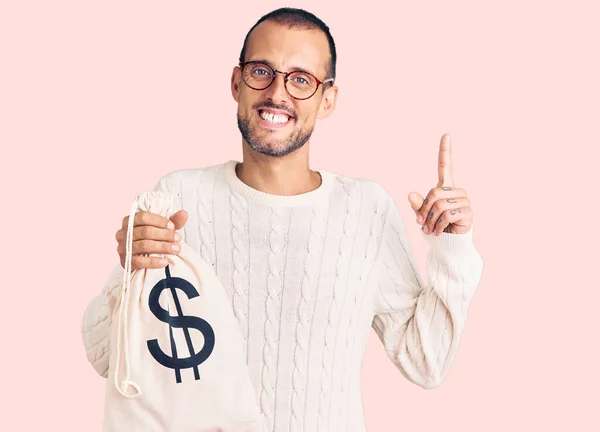 Jovem Homem Bonito Segurando Saco Dinheiro Com Símbolo Dólar Surpreso — Fotografia de Stock