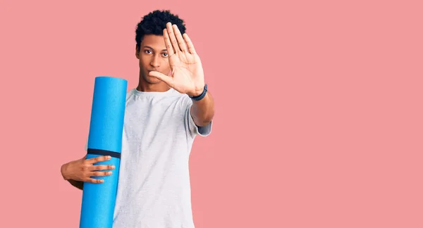 Joven Hombre Afroamericano Sosteniendo Esterilla Yoga Con Mano Abierta Haciendo — Foto de Stock