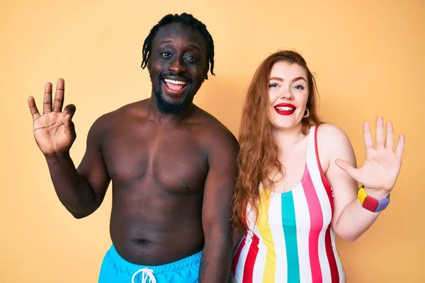 跨种族夫妇身穿泳衣 手指点点八号 面带微笑 自信而快乐 — 图库照片