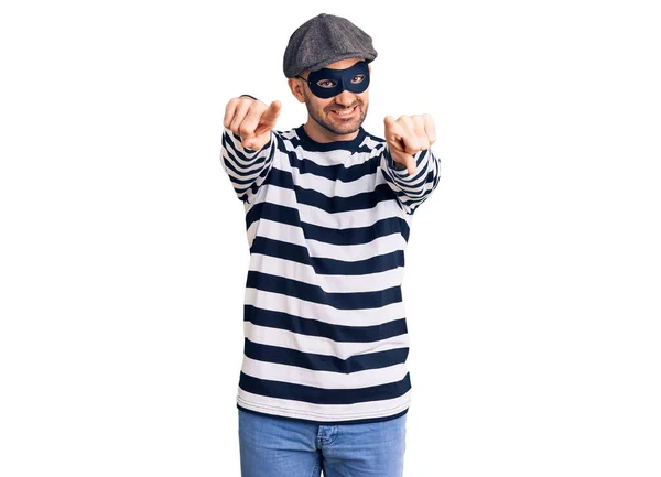 Junger Gutaussehender Mann Mit Einbrechermaske Zeigt Mit Den Fingern Auf — Stockfoto