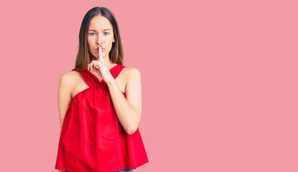 唇に指で静かにするように求めるカジュアルな服を着て美しいブルネットの若い女性 沈黙と秘密の概念 — ストック写真