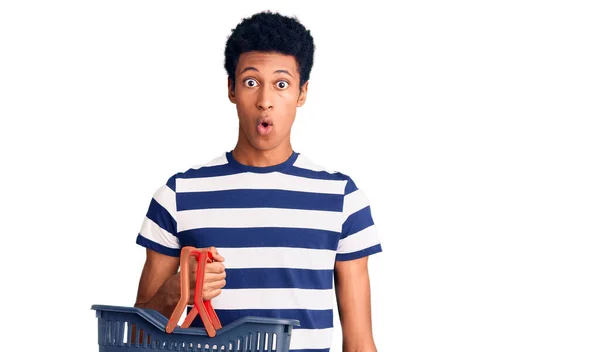 Joven Afroamericano Hombre Celebración Supermercado Cesta Compra Asustado Sorprendido Con —  Fotos de Stock