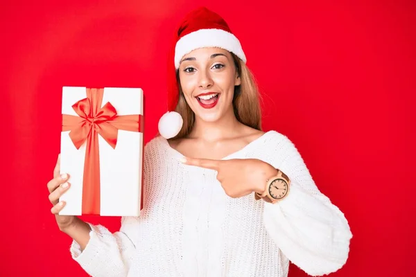 Junge Brünette Frau Mit Weihnachtsmütze Und Einem Geschenk Lächelnd Glücklich — Stockfoto