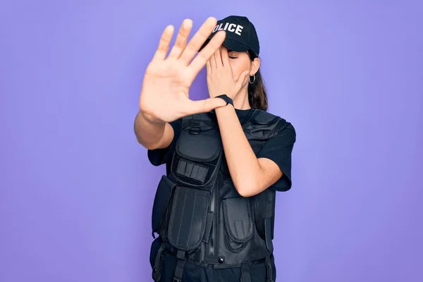 Młoda Policjantka Nosząca Kamizelkę Kuloodporną Fioletowe Tło Zakrywająca Dłońmi Oczy — Zdjęcie stockowe