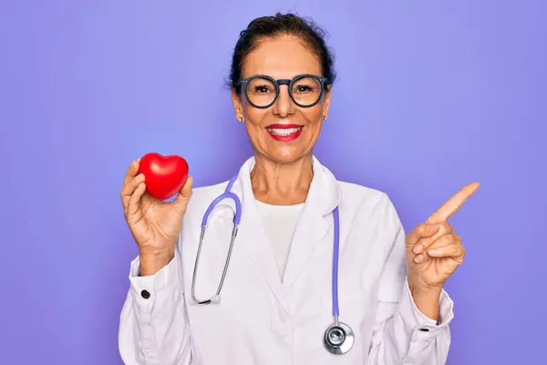 Starszy Kardiolog Średnim Wieku Lekarz Kobieta Trzyma Czerwone Serce Fioletowym — Zdjęcie stockowe