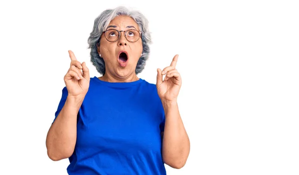 Gri Elbiseli Gözlüklü Şaşkın Şaşırmış Yaşlı Bir Kadın Parmaklarıyla Işaret — Stok fotoğraf