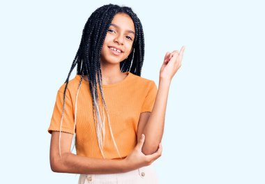 Yüzünde kocaman bir gülümseme olan ve kameraya bakan Afro-Amerikalı tatlı bir kız.. 