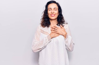 Gündelik kıyafetler giyen, göğsünde elleri kapalı, yüzünde minnet dolu bir jest olan genç ve güzel bir İspanyol kadın. sağlık kavramı. 