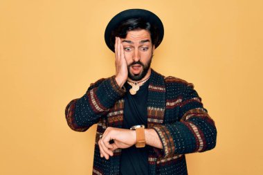 Genç, yakışıklı, bohem, hippi tarzı ve bohem şapkalı bir adam. Saatine bakıyor, endişeli, geç kalmaktan korkuyor.