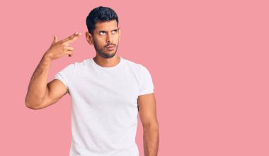 Gündelik giysiler giymiş genç Latin bir adam kendini vuruyor ve öldürüyor. Elini ve parmaklarını silah gibi kullanıyor. İntihar hareketi.. 