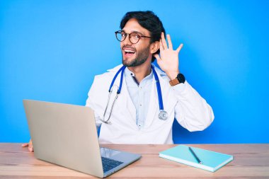 Klinikte çalışan yakışıklı, doktor üniforması giyen, ağzı kulaklarında gülümseyen dedikoduları ve dedikoduları dinleyen bir İspanyol. Sağırlık kavramı. 