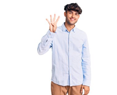 Gündelik tişört giyen genç İspanyol adam gülümseyerek kendinden emin ve mutlu bir şekilde dört numarayı gösteriyor ve işaret ediyor.. 