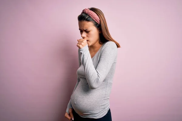 年轻漂亮的少女怀孕了 怀孕的时候 她的背景是孤立的粉色 感觉不舒服 咳嗽是感冒或支气管炎的症状 保健概念 — 图库照片