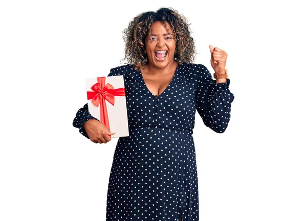 Joven Afroamericana Más Tamaño Mujer Sosteniendo Regalo Gritando Orgulloso Celebrando — Foto de Stock