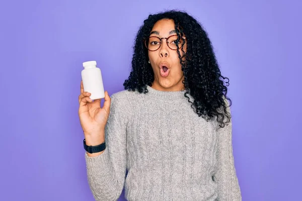 Mujer Rizada Afroamericana Joven Sosteniendo Píldoras Pie Sobre Fondo Púrpura — Foto de Stock