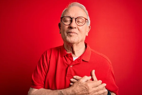Šedovlasý Starší Muž Brýlemi Neformálním Tričkem Červeném Pozadí Úsměvem Prsou — Stock fotografie