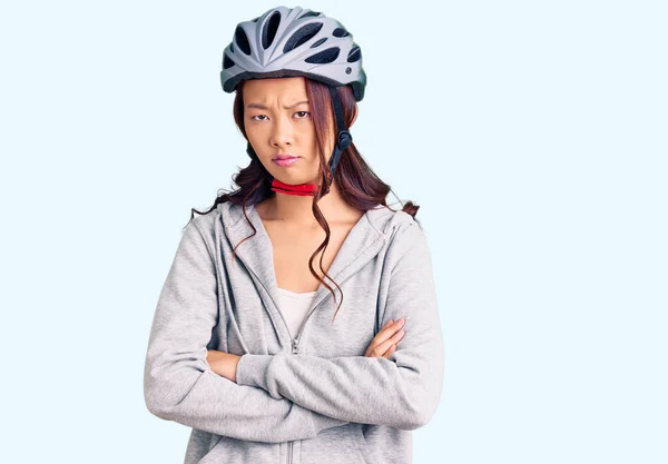 若い美しい中国の少女は 交差腕で顔に懐疑的かつ神経 不承認式自転車ヘルメットを着用 否定的な人 — ストック写真