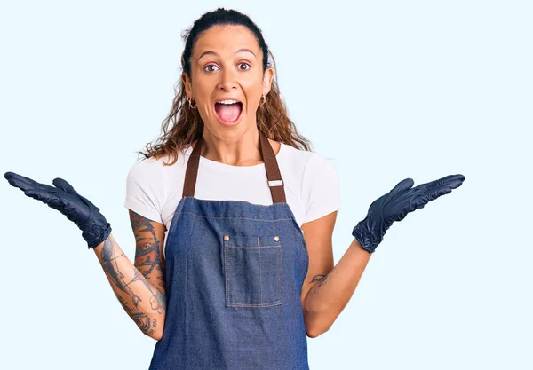 Junge Hispanische Frau Mit Tätowierung Friseurschürze Und Handschuhen Feiert Sieg — Stockfoto