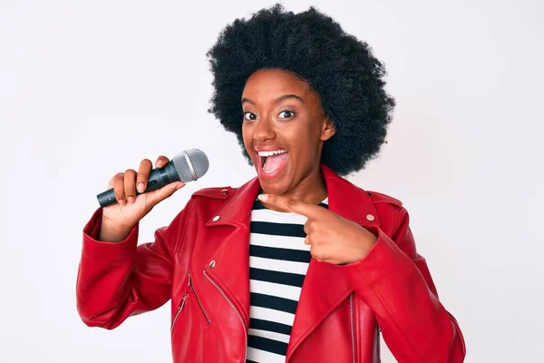 Νεαρή Αφροαμερικανή Τραγουδίστρια Που Τραγουδάει Μικρόφωνο Χαμογελώντας Χαρούμενη Δείχνοντας Χέρι — Φωτογραφία Αρχείου
